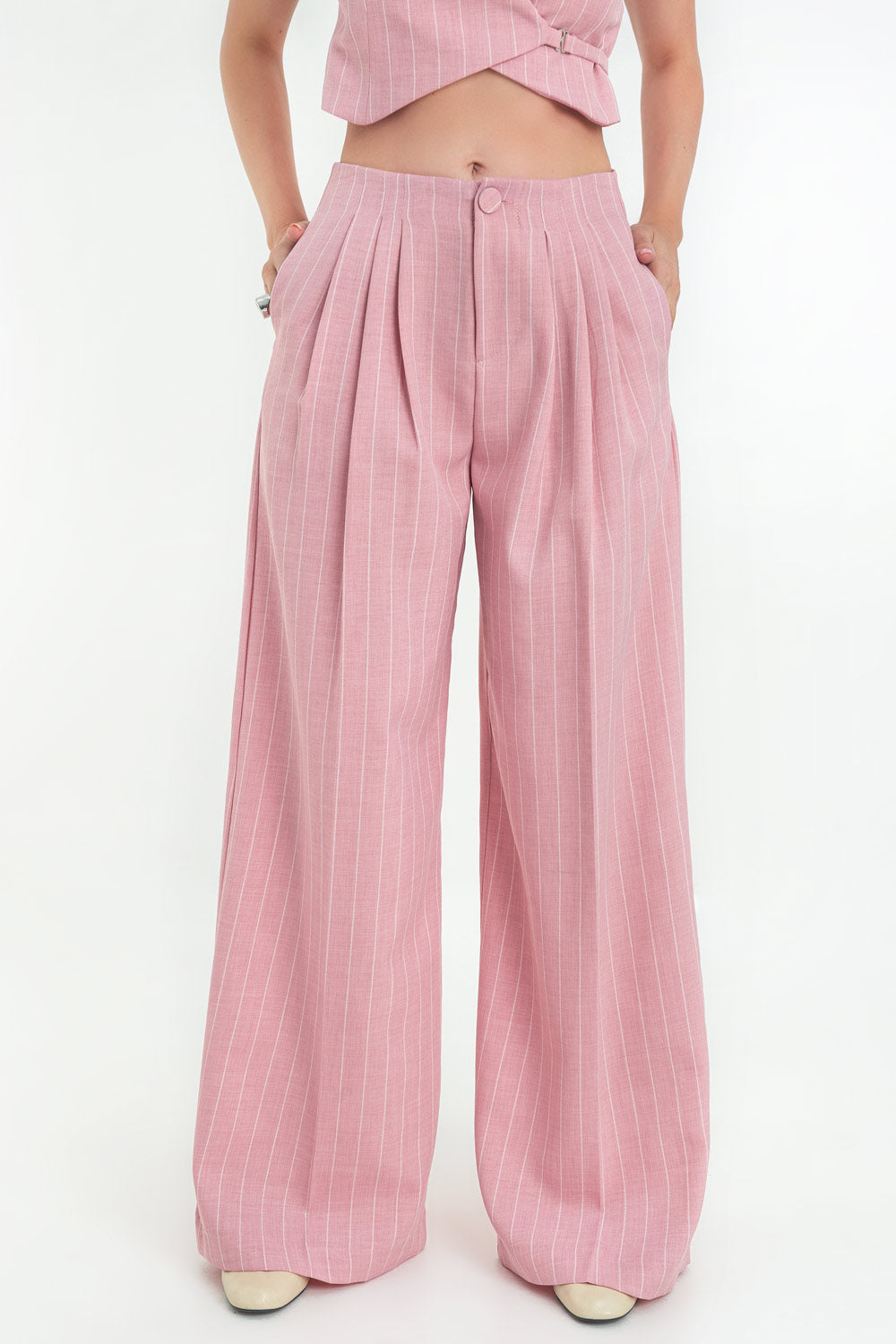 Pantalón de estampado rayas, fit palazzo, cintura alta con pinzas frontales, bolsillos delanteros, raya frontal y posterior. Cierre frontal con botón y cremallera oculta.