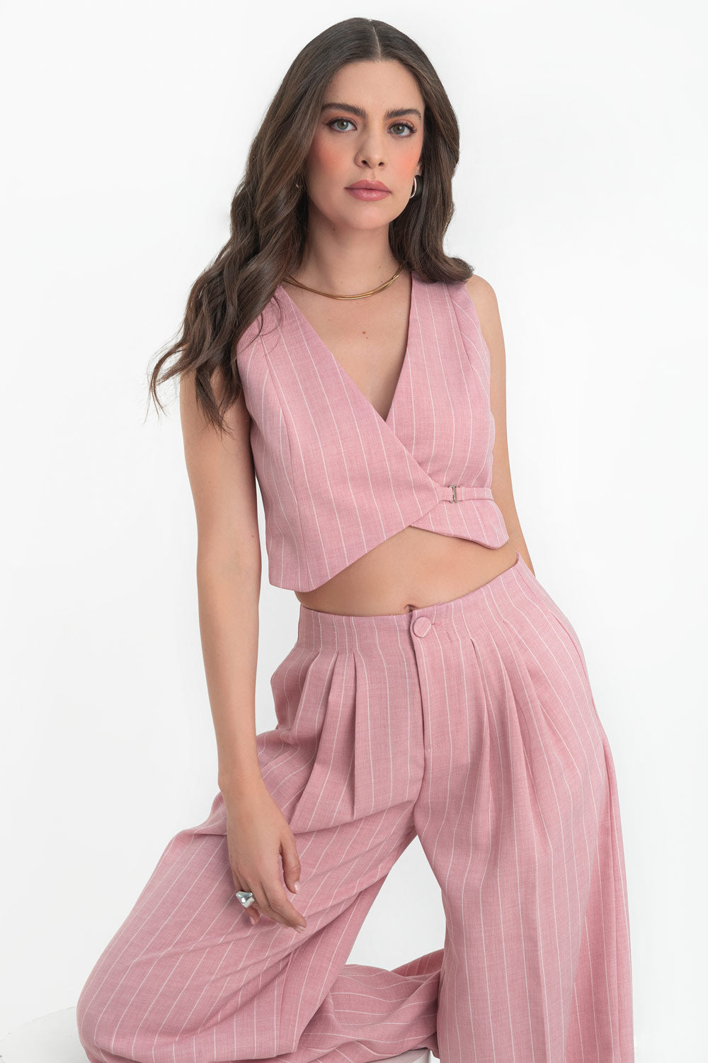 Pantalón de estampado rayas, fit palazzo, cintura alta con pinzas frontales, bolsillos delanteros, raya frontal y posterior. Cierre frontal con botón y cremallera oculta.
