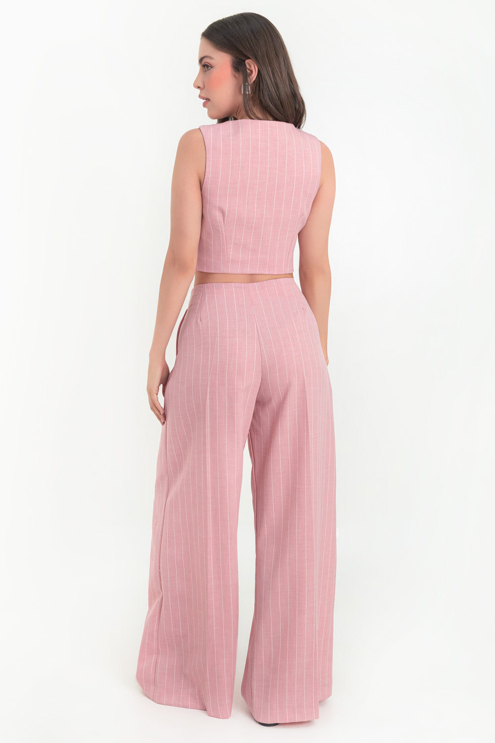 Pantalón de estampado rayas, fit palazzo, cintura alta con pinzas frontales, bolsillos delanteros, raya frontal y posterior. Cierre frontal con botón y cremallera oculta.