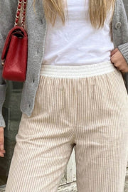 Pantalón de estampado rayas, fit recto, bolsillos delanteros y cintura alta elástica con pretina boxer en contraste.