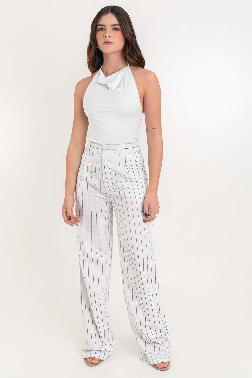 Pantalón de lino, fit wide leg, estampado rayas, cintura alta con pretina elástica posterior y trabillas, pinzas frontales, bolsillos delanteros y vivo decorativo posterior. Cierre frontal con botón en contraste y cremallera oculta.