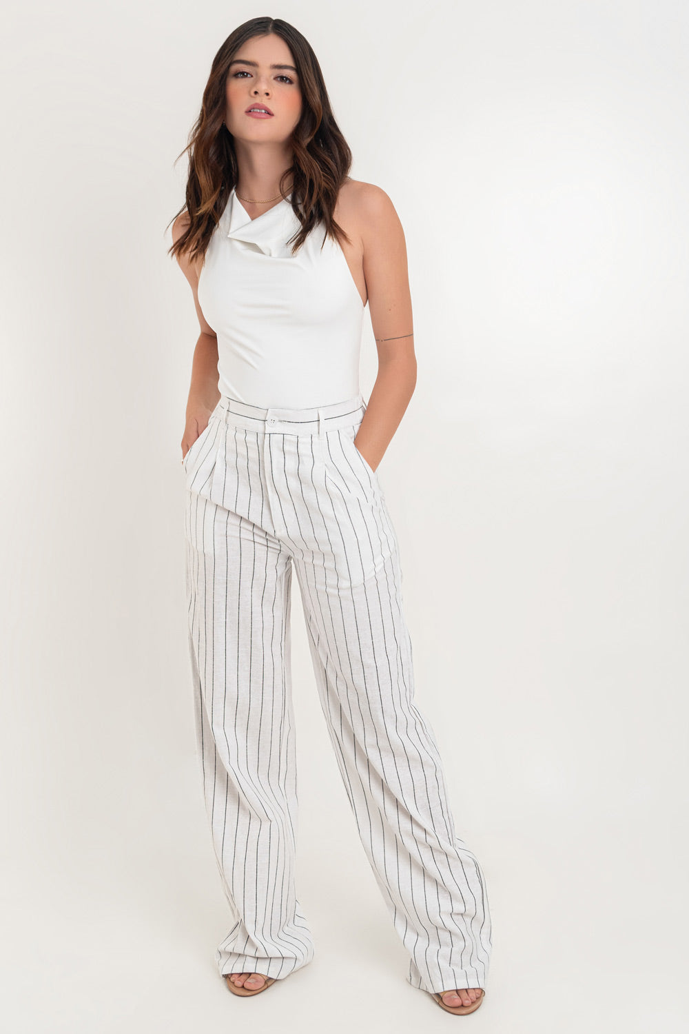 Pantalón de lino, fit wide leg, estampado rayas, cintura alta con pretina elástica posterior y trabillas, pinzas frontales, bolsillos delanteros y vivo decorativo posterior. Cierre frontal con botón en contraste y cremallera oculta.
