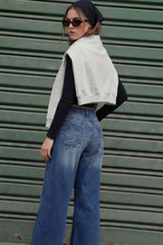 Pantalón wide leg de denim, cintura media con pretina y trabillas, bolsillos delanteros y traseros de parche con bordado de estrella. Cierre frontal con botón y cremallera oculta.