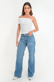 Pantalón light denim de pierna amplia, cintura alta con pretina, trabillas, bolsillos delanteros y traseros de parche. Cierre frontal con botón y cremallera oculta. Detalle de rotos en bajo.