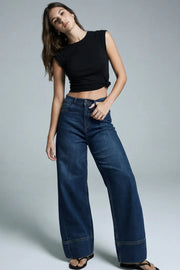 Pantalón de denim, fit wide leg, tiro alto, pretina con trabillas, bolsillos delanteros y traseros de parche. Cierre frontal con botón y cremallera oculta. Detalle de trabilla ajustable posterior.
