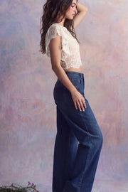 Pantalón de denim, fit wide leg, tiro alto, pretina con trabillas, bolsillos delanteros y traseros de parche. Cierre frontal con botón y cremallera oculta.