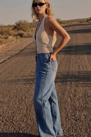 Pantalón de denim, fit wide leg, tiro alto, pretina con trabillas, bolsillos delanteros y traseros de parche. Cierre frontal con botón y cremallera oculta.