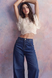Pantalón de denim, fit wide leg, tiro alto, pretina con trabillas, bolsillos delanteros y traseros de parche. Cierre frontal con botón y cremallera oculta.