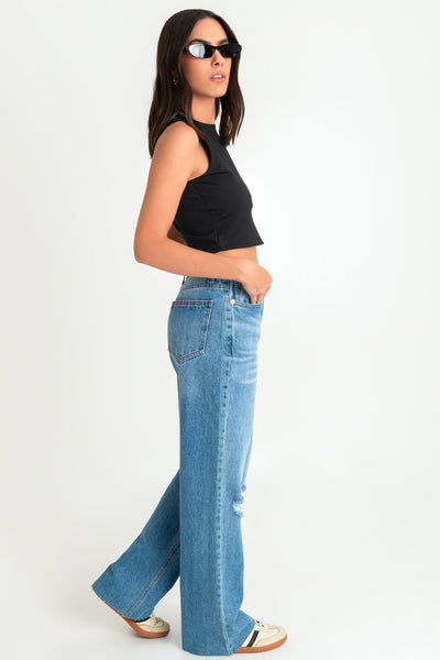 Pantalón wide leg de denim con rotos, tiro alto, bolsillos delanteros y traseros de parche. Cierre con botón y cremallera oculta. Detalle de rotos en bajo.