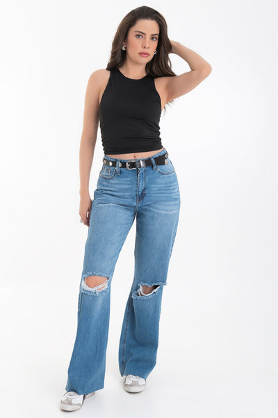 Pantalón wide leg de denim con rotos, tiro alto, bolsillos delanteros y traseros de parche. Cierre con botón y cremallera oculta. Detalle de rotos en bajo.