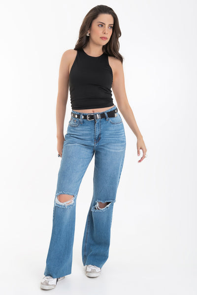 Pantalón wide leg de denim con rotos, tiro alto, bolsillos delanteros y traseros de parche. Cierre con botón y cremallera oculta. Detalle de rotos en bajo.