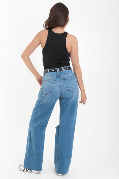 Pantalón wide leg de denim con rotos, tiro alto, bolsillos delanteros y traseros de parche. Cierre con botón y cremallera oculta. Detalle de rotos en bajo.