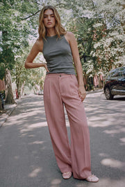 Pantalón de fit wide leg, cintura alta, pretina con detalle v posterior y trabillas, pinzas frontales, bolsillos delanteros y vivos decorativos posteriores. Cierre frontal con botón en contraste y cremallera ocultas.
