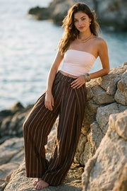 Pantalón de estampado rayas, wide leg de cintura alta con pretina, pinzas con detalle decorativo frontal, cierre frontal con broche y cremallera ocultos.