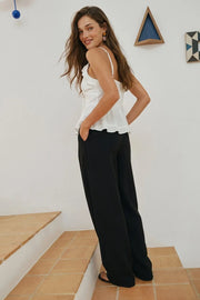 Pantalón wide leg de cintura alta con pretina, pinzas con detalle decorativo frontal, bolsillos delanteros, cierre frontal con broche y cremallera ocultos.