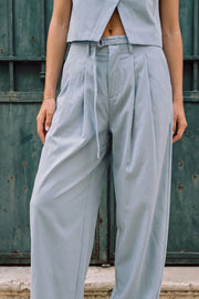 Pantalón de fit balloon, pinzas frontales, cintura alta con pretina, trabillas y cinturón del mismo tejido con hebilla en contraste, bolsillos delanteros, cierre frontal con broche y cremallera ocultos.