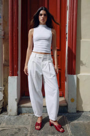Pantalón fit balloon, cintura alta con pretina elástica posterior y trabillas, bolsillos delanteros, pinzas frontales, cierre frontal con botones y cremallera oculta.