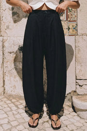 Pantalón fit barrel de cintura media con pretina elástica posterior, bolsillos delanteros, pinzas frontales y rib elástico en bajo. Cierre frontal con botón y cremallera oculta.
