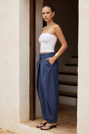 Pantalón fit barrel de cintura media, cruce doble decorativo con pretina y trabillas, pinzas frontales y vivos decorativos posteriores. Cierre frontal con broche y cremallera ocultos.