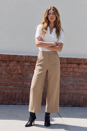 Pantalón de fit culotte, cintura alta con pretina, raya frontal y posterior, bolsillos delanteros y vivos decorativos posteriores. Cierre frontal con broche y cremallera ocultos.