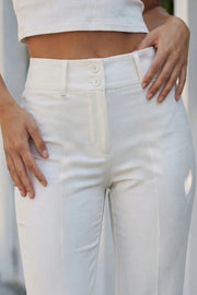 Pantalón ajustado de fit flare, cintura alta con pretina y trabillas, raya frontal y posterior, cierre con cremallera oculta y botones.
