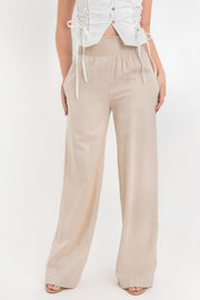 Pantalón fluido de fit recto, cintura alta elástica con pretina fruncida, olanes en borde y bolsillos delanteros.
