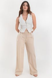 Pantalón fluido de fit recto, cintura alta elástica con pretina fruncida, olanes en borde y bolsillos delanteros.
