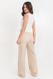 Pantalón fluido de fit recto, cintura alta elástica con pretina fruncida, olanes en borde y bolsillos delanteros.
