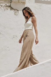 Pantalón de fit wide leg, pinzas frontales, cintura alta con pretina y cruce frontal decorativo. Cierre lateral con cremallera oculta.