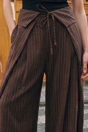 Pantalón de estampado rayas, fit palazzo, cintura alta, pretina con solapa y lazo amarrable frontal, pinzas frontales con detalles decorativos y bolsillos delanteros. Cierre frontal con botón y cremallera oculta.