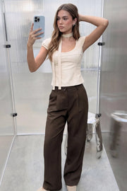 Pantalón de fit recto, cintura alta con pretina y trabillas, bolsillos delanteros y vivos decorativos posteriores, pinzas frontales. Cierre con botón y cremallera oculta.