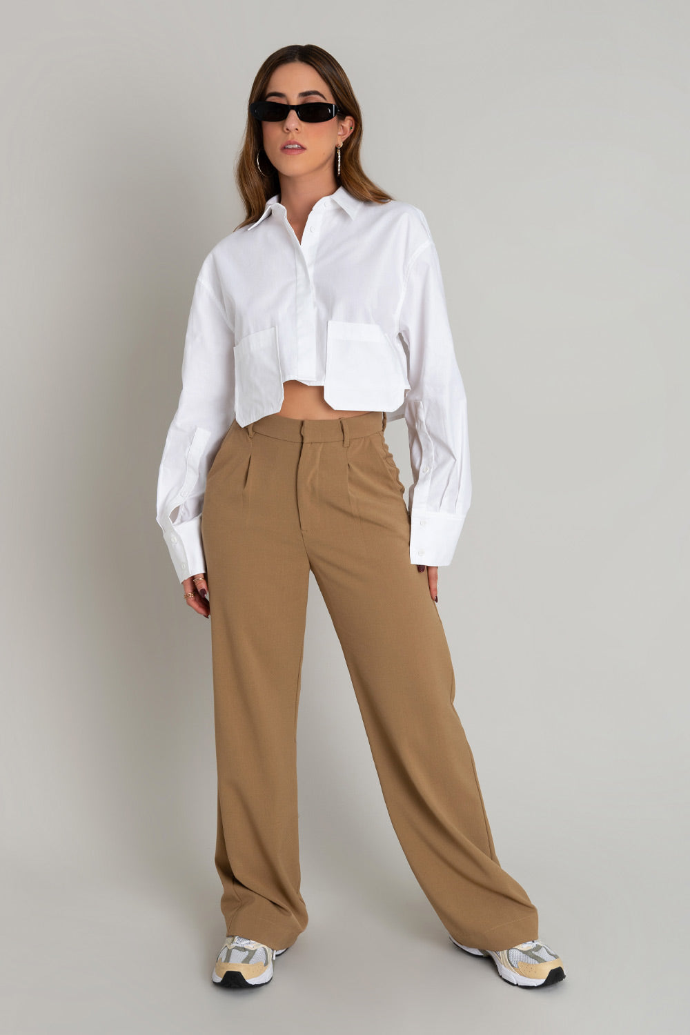 Pantalón de fit wide leg, cintura alta con pretina y trabillas, pinzas frontales, bolsillos delanteros, cierre frontal con broche y cremallera ocultos.