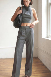 Pantalón de fit wide leg, cintura alta con pretina y trabillas, pinzas frontales con raya frontal, bolsillos delanteros, vivo decorativo posterior, cierre frontal con broche y cremallera ocultos.
