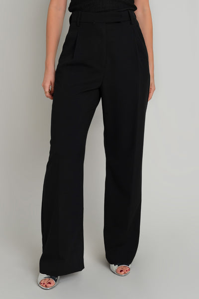Pantalón de fit wide leg, cintura alta con pretina y trabillas, pinzas frontales con raya frontal, bolsillos delanteros, vivo decorativo posterior, cierre frontal con broche y cremallera ocultos.