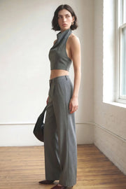 Pantalón de fit wide leg, cintura alta con pretina y trabillas, pinzas frontales con raya frontal, bolsillos delanteros, vivo decorativo posterior, cierre frontal con broche y cremallera ocultos.