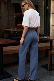 Pantalón de fit wide leg, cintura alta con pretina y trabillas, pinzas frontales con raya frontal, bolsillos delanteros, vivo decorativo posterior, cierre frontal con broche y cremallera ocultos.