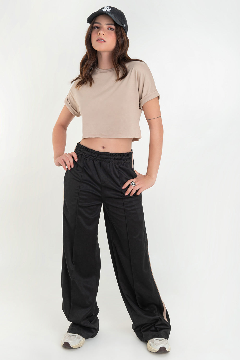 Pantalón fluido de fit recto, cintura media con pretina elástica, bolsillos delanteros, costura frontal y raya lateral decorativa en contraste.