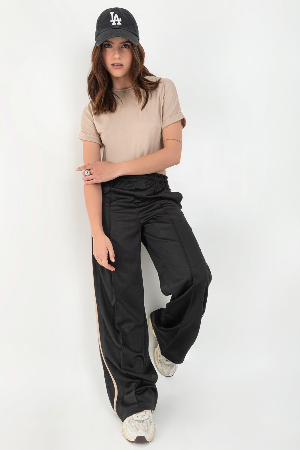 Pantalón fluido de fit recto, cintura media con pretina elástica, bolsillos delanteros, costura frontal y raya lateral decorativa en contraste.
