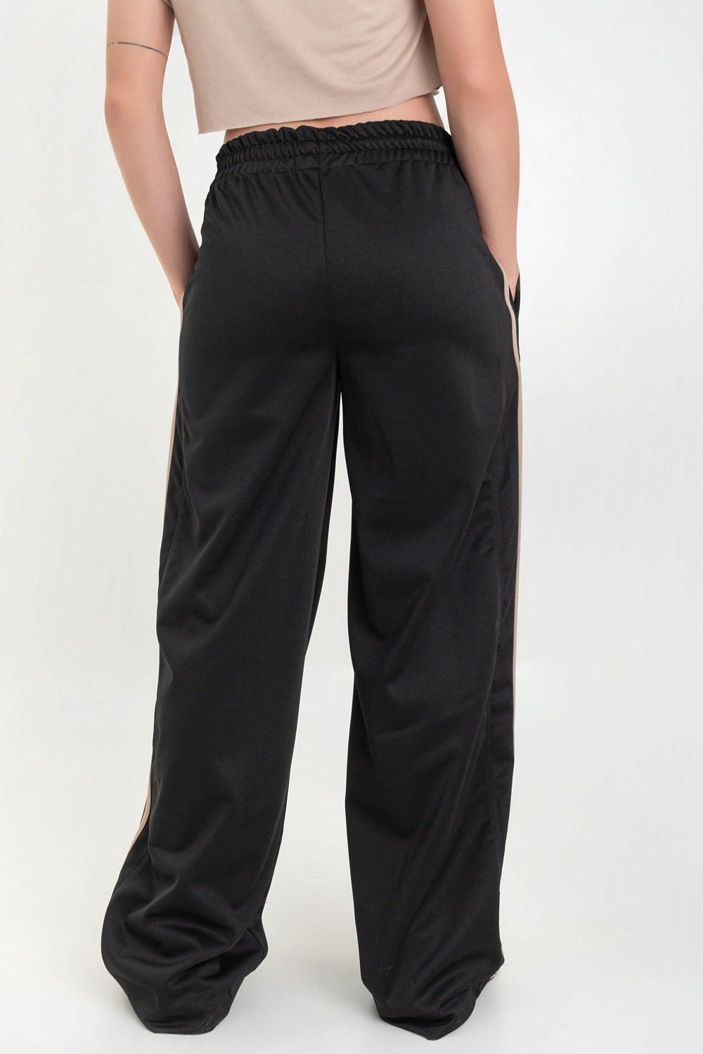 Pantalón fluido de fit recto, cintura media con pretina elástica, bolsillos delanteros, costura frontal y raya lateral decorativa en contraste.