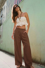 Pantalón fluido de fit wide leg, pinzas frontales, bolsillos delanteros y cintura alta con pretina elástica posterior.