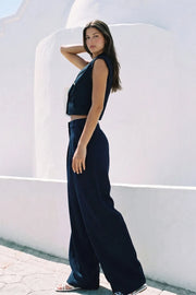 Pantalón de fit wide leg, cintura alta con pretina, trabillas, pinzas frontales y bolsillos delanteros. Cierre frontal con broche y cremallera ocultos.