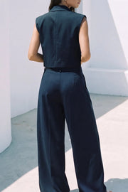 Pantalón de fit wide leg, cintura alta con pretina, trabillas, pinzas frontales y bolsillos delanteros. Cierre frontal con broche y cremallera ocultos.