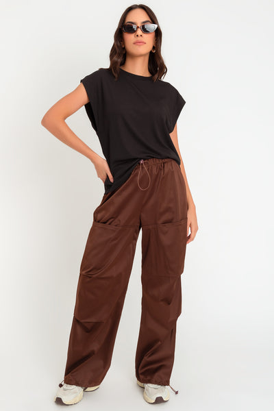 Pantalón parachute satinado de cintura alta con pretina elástica y jareta ajustable, de pierna amplia, plisados decorativos frontales, detalle de bajo con jaretas elásticas ajustables.