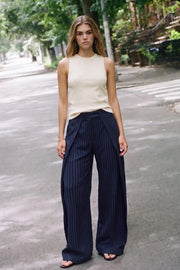 Pantalón wide leg de estampado rayas, cintura alta con pretina, pinzas con detalle decorativo frontal y bolsillos delanteros. Cierre frontal con broche y cremallera ocultos.