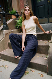 Pantalón wide leg de estampado rayas, cintura alta con pretina, pinzas con detalle decorativo frontal y bolsillos delanteros. Cierre frontal con broche y cremallera ocultos.