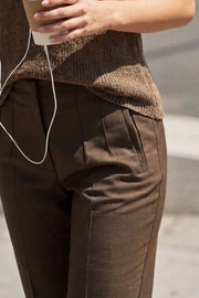 Pantalón de fit recto, cintura alta con pinzas, vivos decorativos frontales, detalle posterior en v, raya frontal y posterior. Cierre frontal con cremallera oculta.