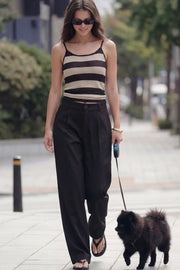 Pantalón de fit wide leg, cintura alta con pretina y trabillas, pinzas frontales, bolsillos delanteros y vivos decorativos posteriores. Cierre frontal con botón y cremallera oculta.