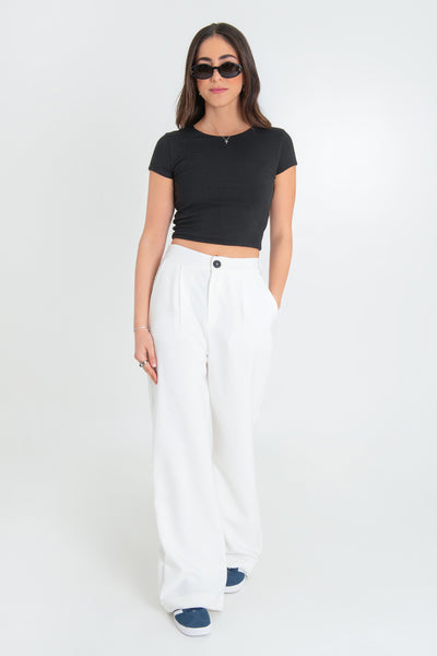 Pantalón de fit wide leg, pinzas frontales, bolsillos delanteros, cintura alta con pretina elástica posterior, cierre frontal con cremallera oculta y botón en contraste.