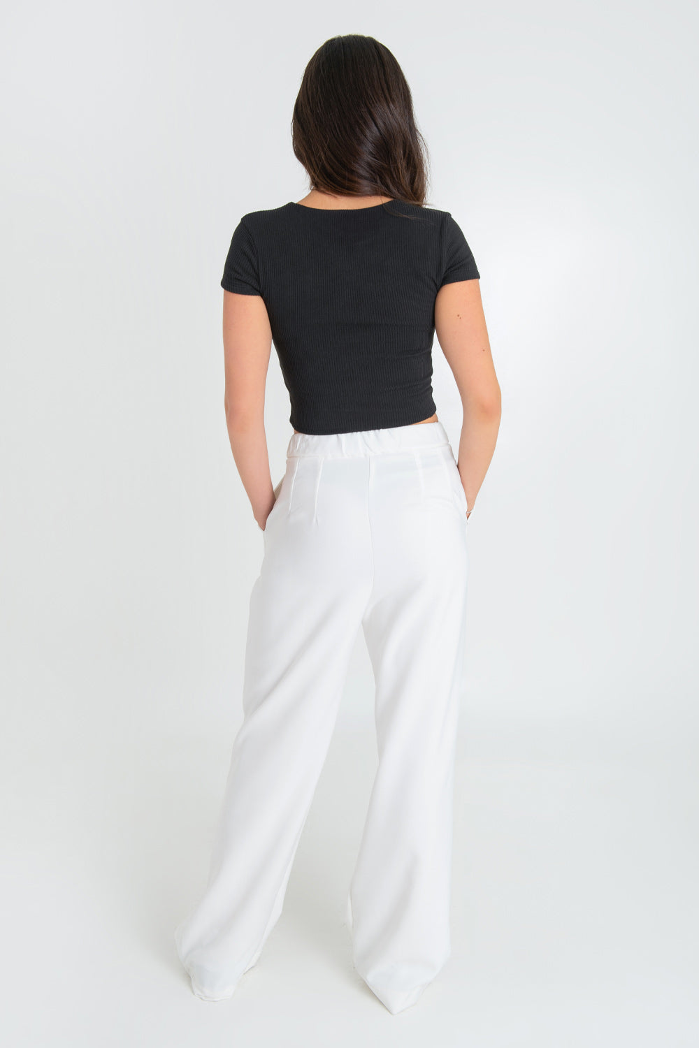 Pantalón de fit wide leg, pinzas frontales, bolsillos delanteros, cintura alta con pretina elástica posterior, cierre frontal con cremallera oculta y botón en contraste.