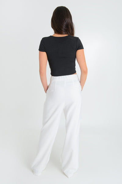 Pantalón de fit wide leg, pinzas frontales, bolsillos delanteros, cintura alta con pretina elástica posterior, cierre frontal con cremallera oculta y botón en contraste.